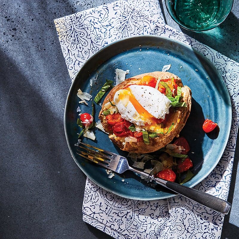 Baked potato with saucy tomatoes and poached egg