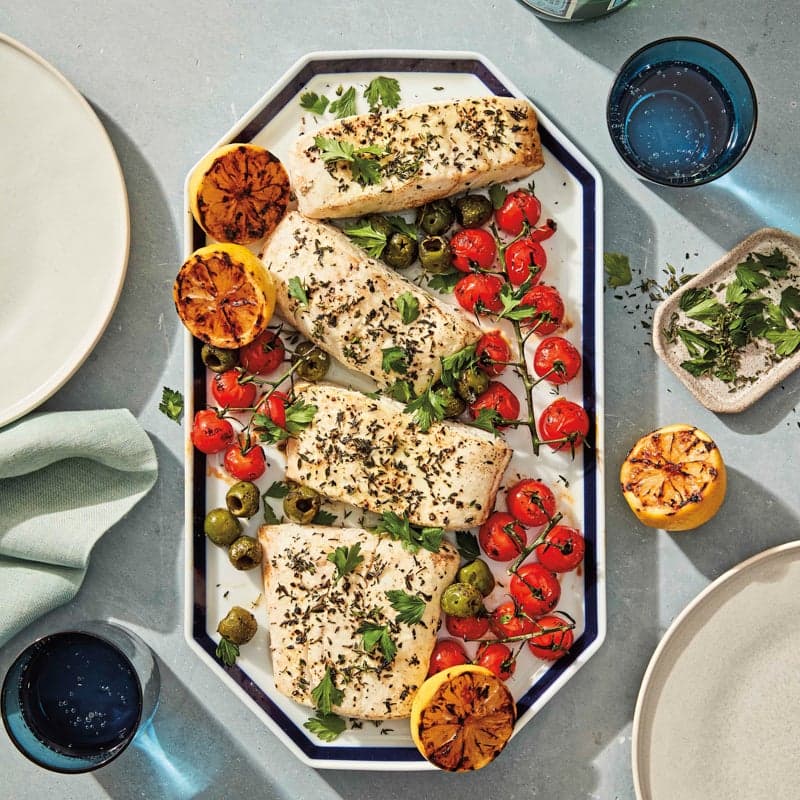Grilled halibut with charred tomatoes, lemons, and olives
