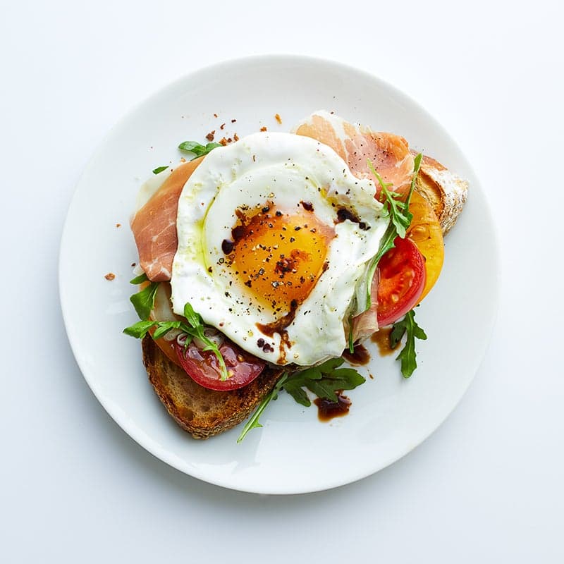 Fried egg, prosciutto and arugula breakfast toast