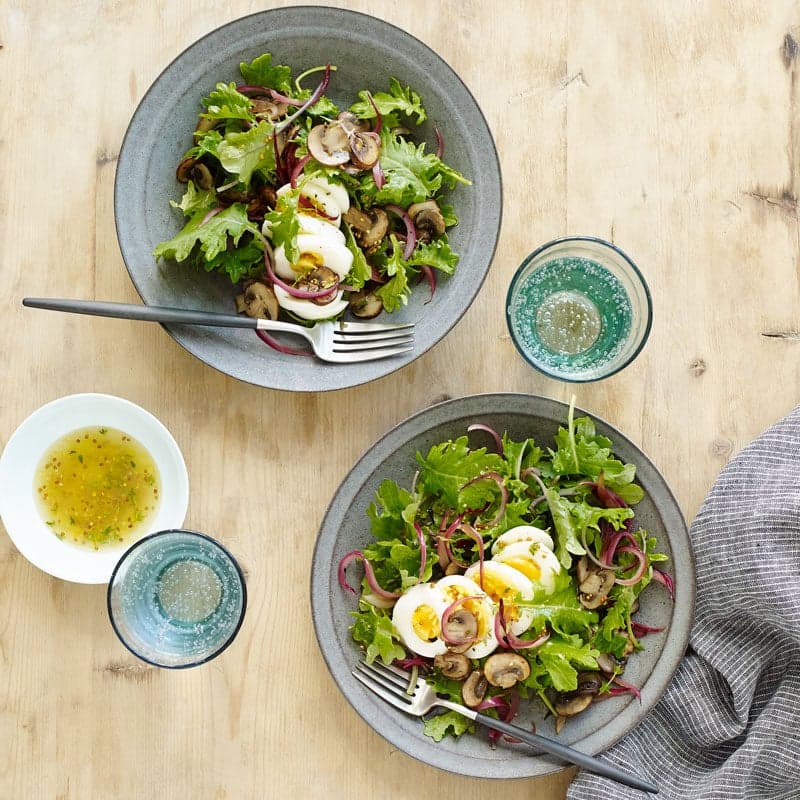 Warm kale salad with onion, mushrooms, and egg